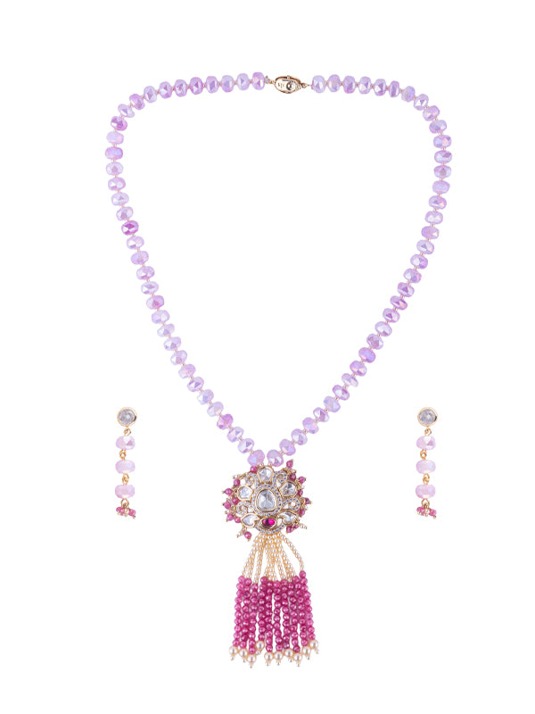 A purple beaded necklace with a gold tone clasp and a central floral pendant