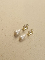 Load image into Gallery viewer, gold-toned drop earrings with teardrop-shaped white freshwater pearls and small clear rhinestone accents