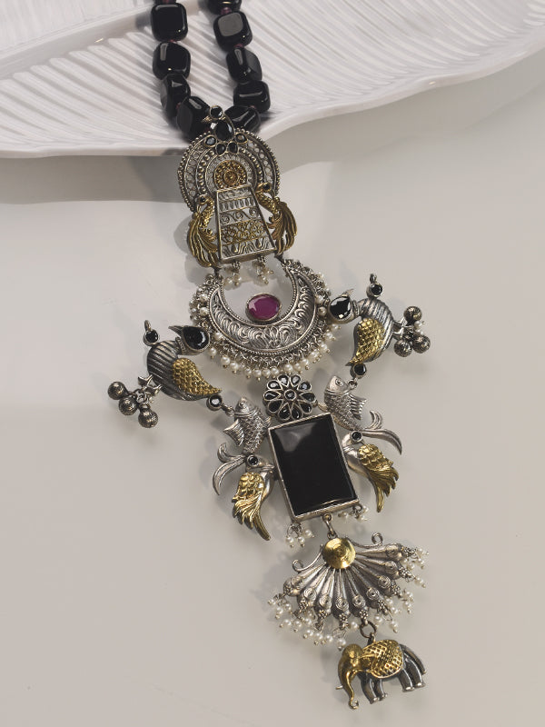 Ornate necklace with black beads and silver and gold pendants 