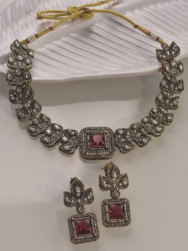 Ornate necklace and earrings set with red stones 