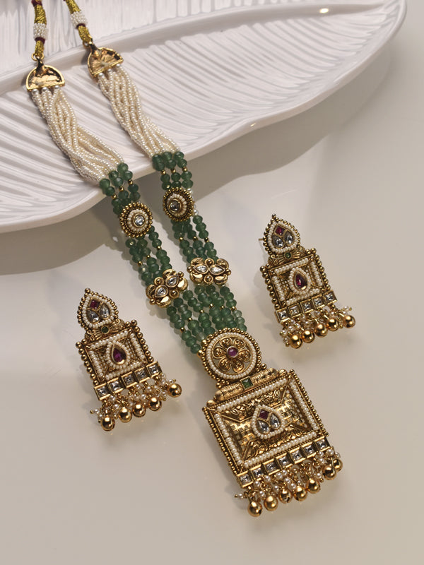  golden and green beaded earrings on a white dish