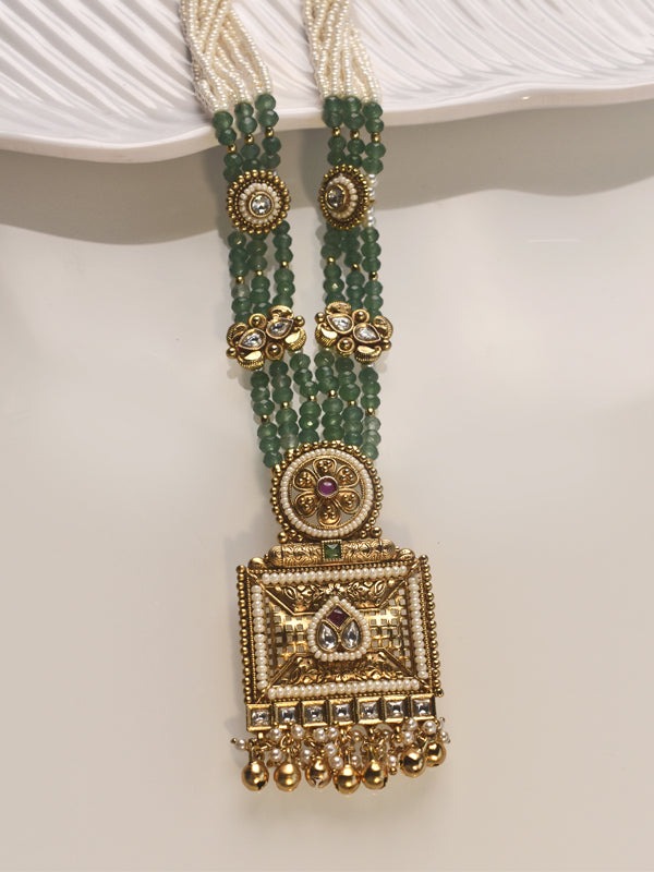Gold and green beaded necklace on a white surface