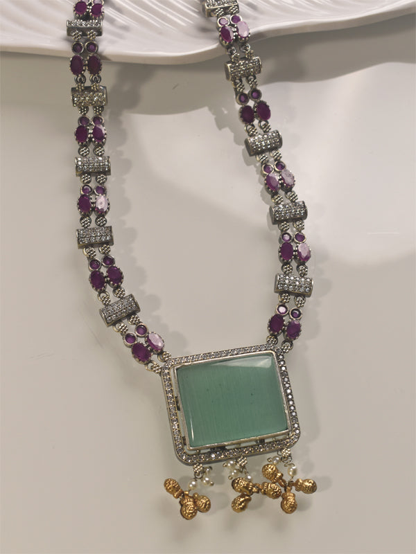 Necklace with purple stones and a green center piece 