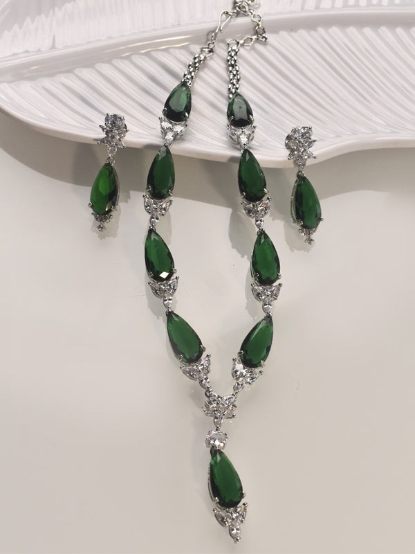 Green gemstone necklace and earrings on a white background