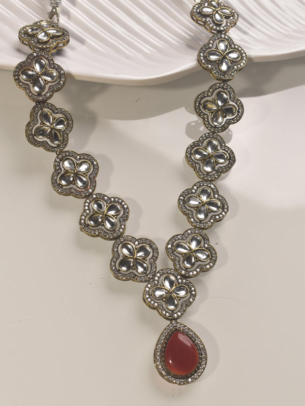  necklace with floral designs and a red stone