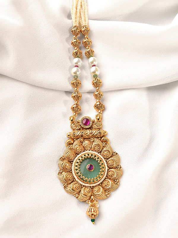 Decorative gold necklace with gemstones on a white fabric background