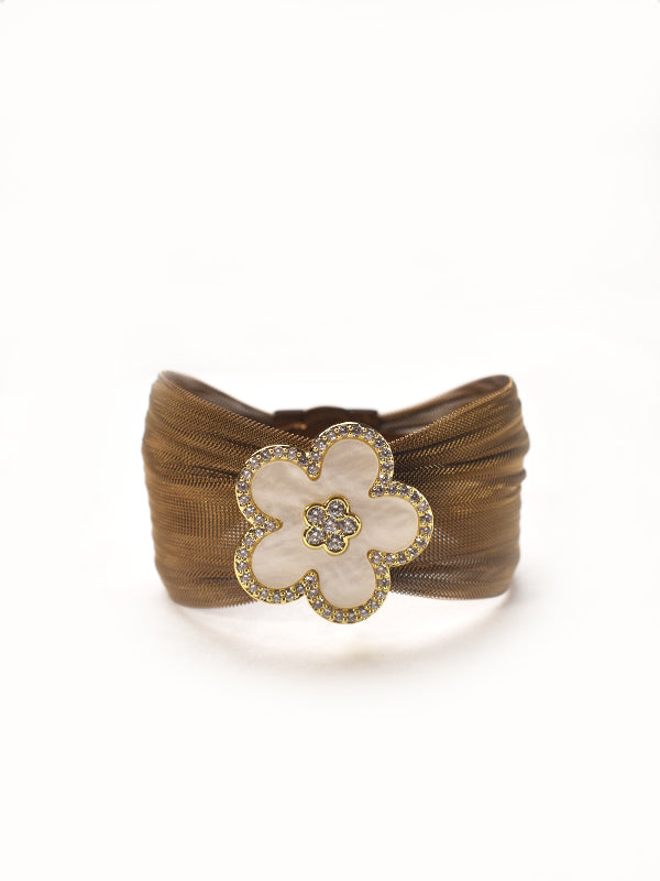 Brown woven cuff bracelet with a decorative white flower and golden accents 