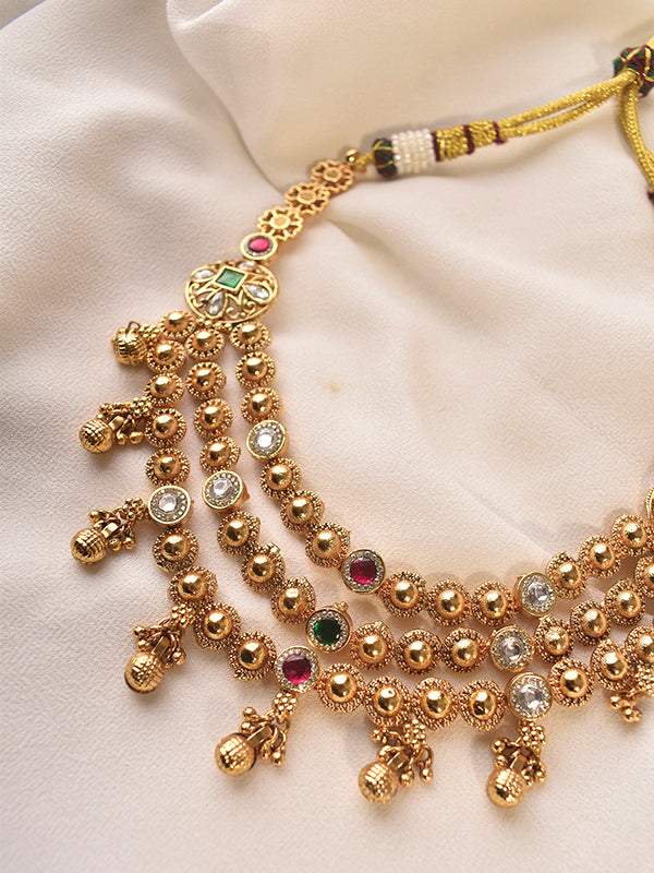 Gold necklace with intricate design and gemstones 