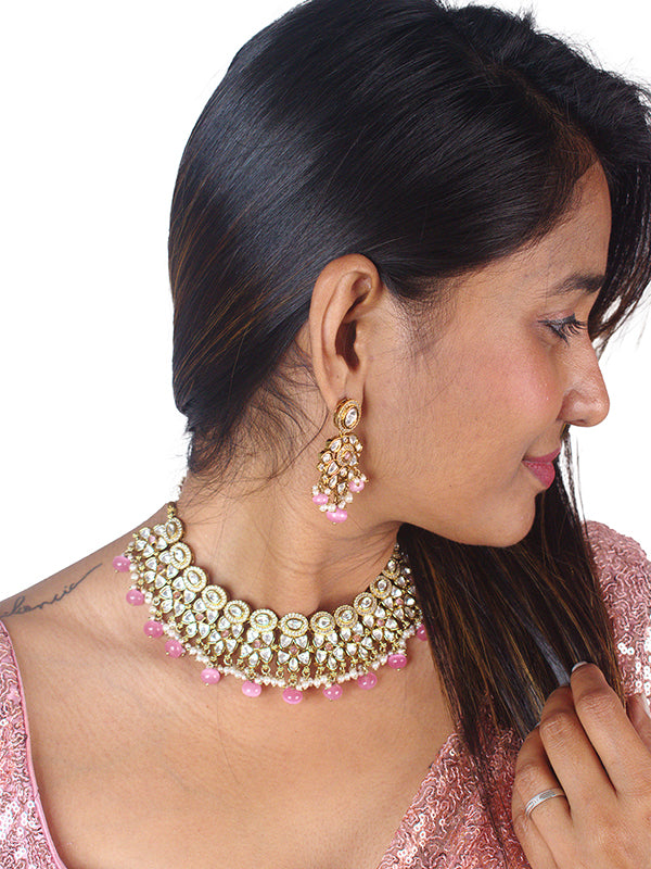 Golden necklace and earrings with pink beads 