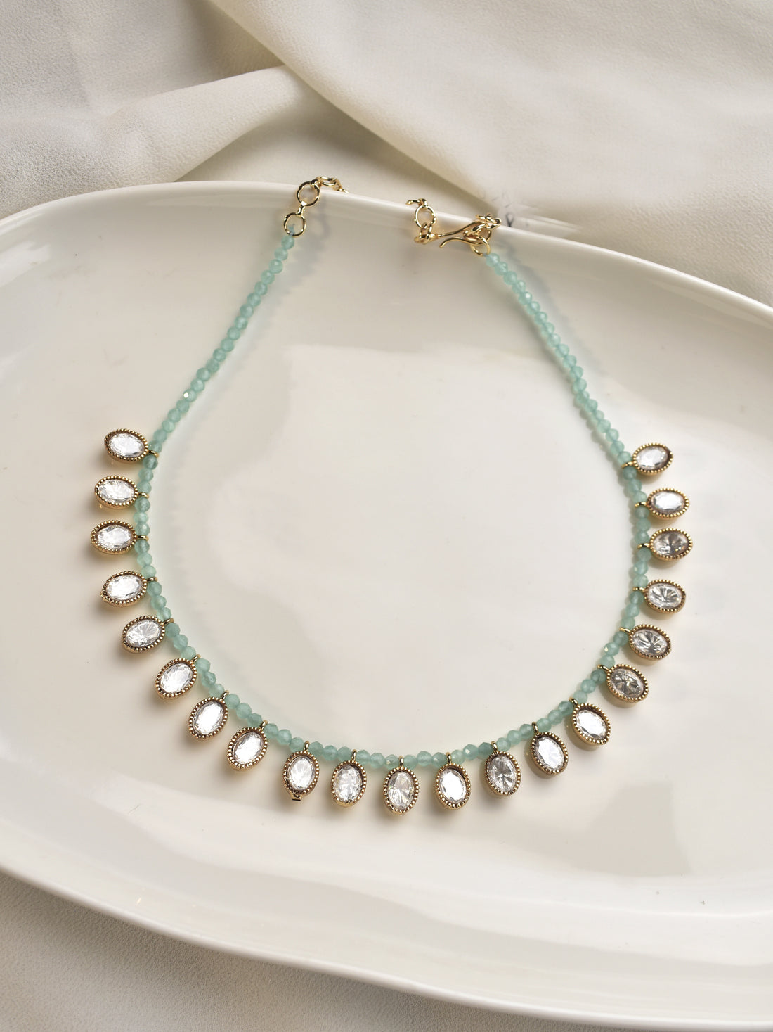 Necklace with small round beads on a white Kundan
