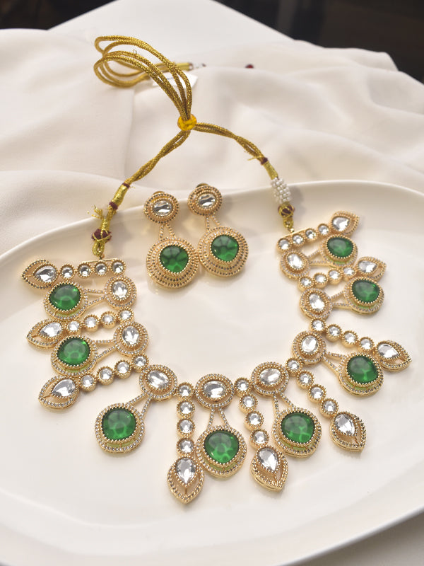 Ornate gold necklace with green gemstones 