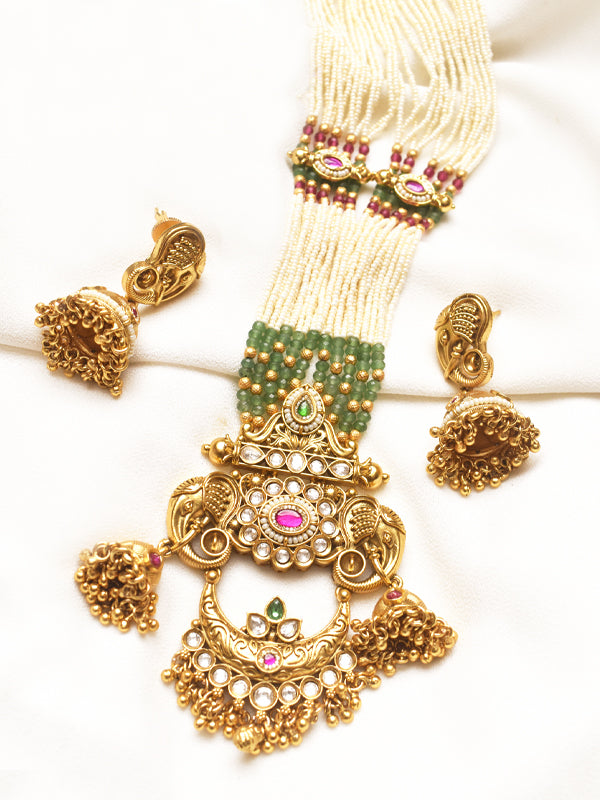 Ornate golden necklace with green and pink stones 
