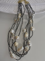 Load image into Gallery viewer, A layered pearl necklace with silver and gold-colored beads, 

