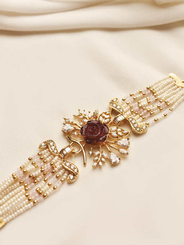 Pearl and golden bracelet with a central gemstone 