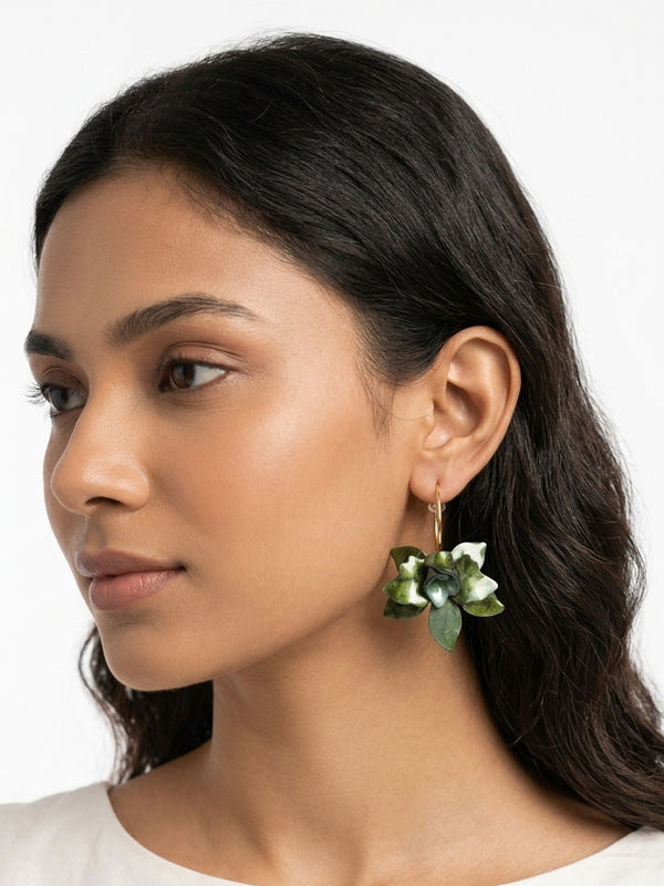Woman wearing a pair of leaf-shaped earrings 