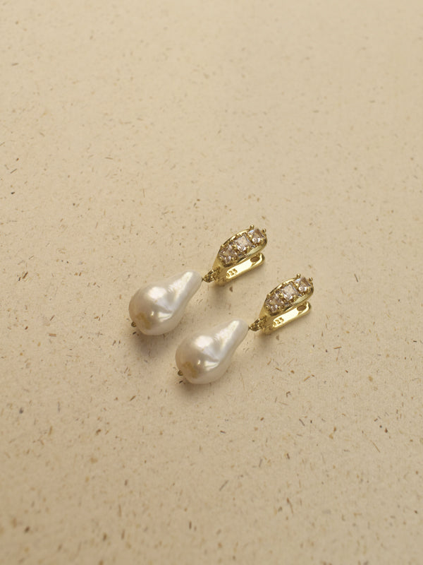 Gold toned drop earrings with teardrop shaped white freshwater pearls and small clear rhinestone accents